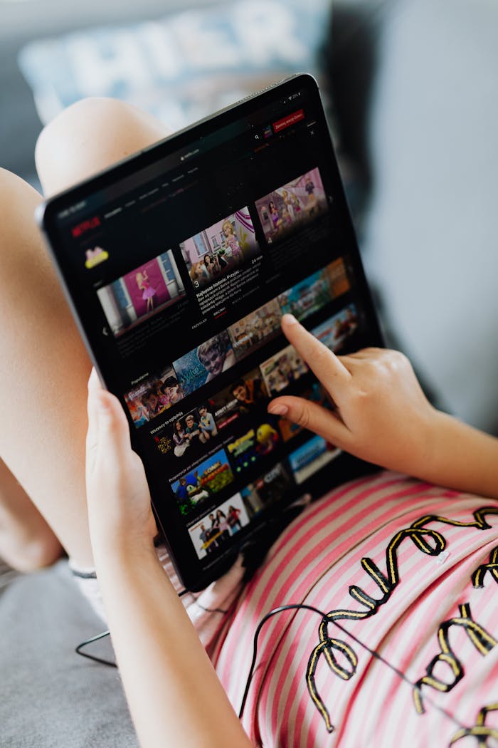 about-us Young girl using a digital tablet indoors, browsing media content during leisure time.